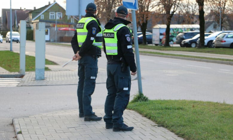 lietuvos policijos pareigunai stovi salia kelio