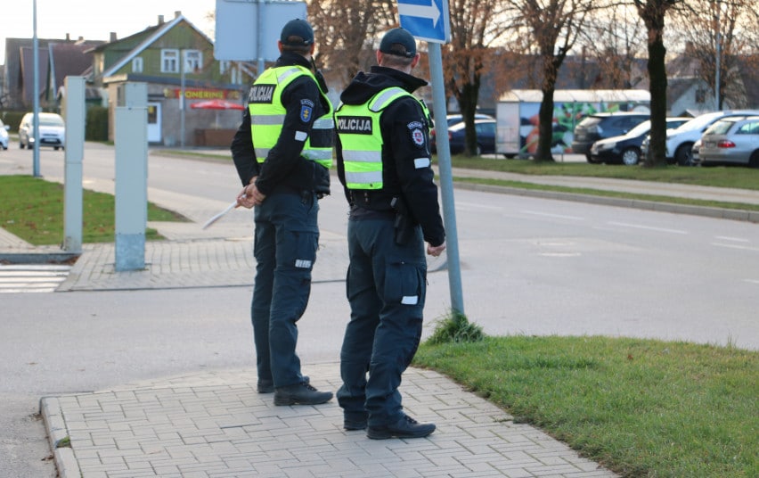 lietuvos policijos pareigunai stovi salia kelio