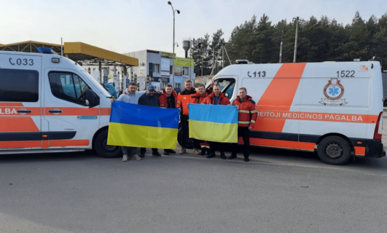 zmones su ukrainos veliava prie greitosios medicinos pagalbos automobiliu