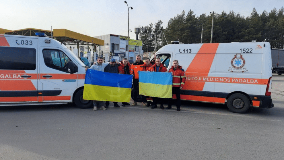 zmones su ukrainos veliava prie greitosios medicinos pagalbos automobiliu