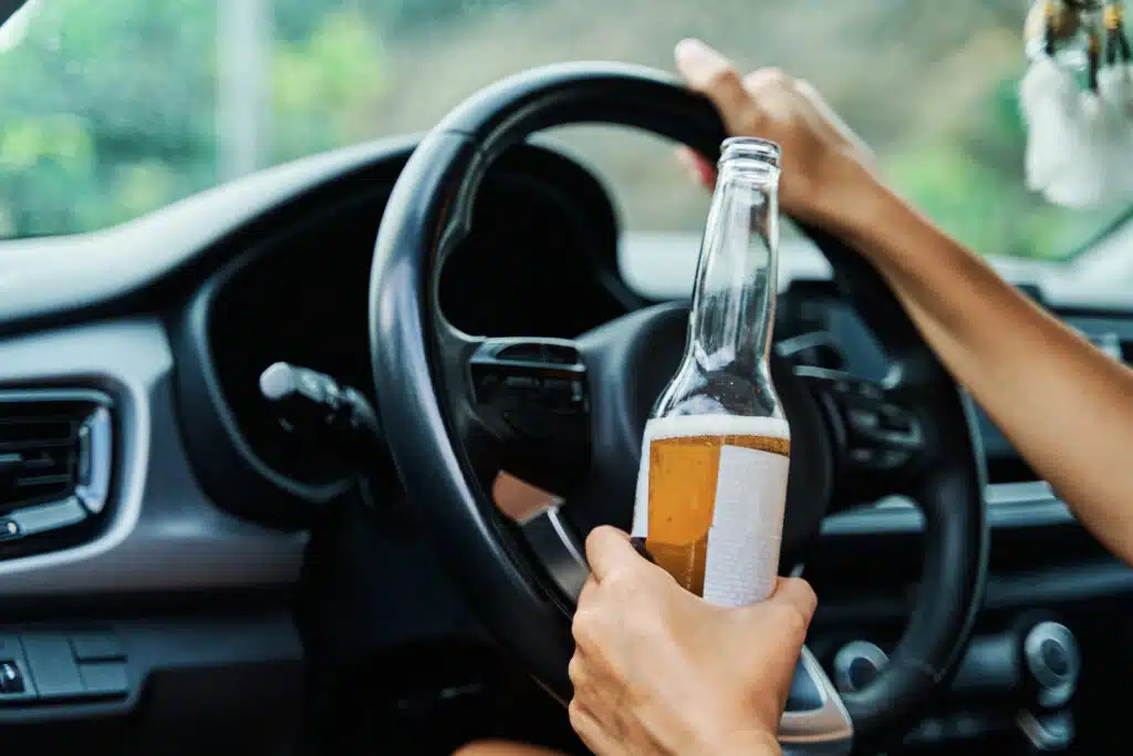 atidarytas butelis alkoholio automobilio salone