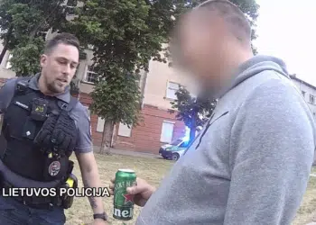 policijos pareigunas vyras su alaus skardine