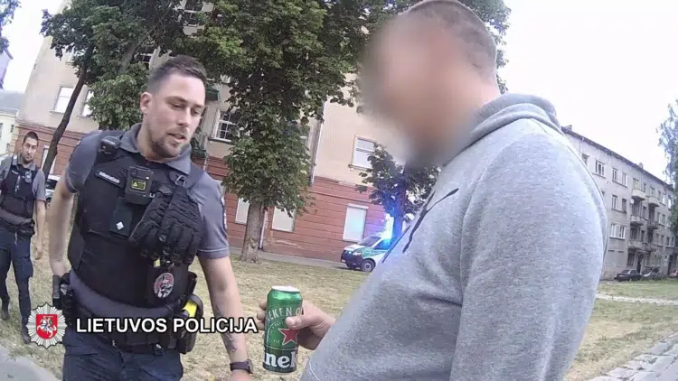 policijos pareigunas vyras su alaus skardine