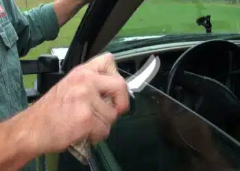 vyras su peiliu prie automobilio