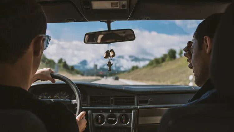 du vyrai vairuotojas ir keleivis vaziuoja automobiliu