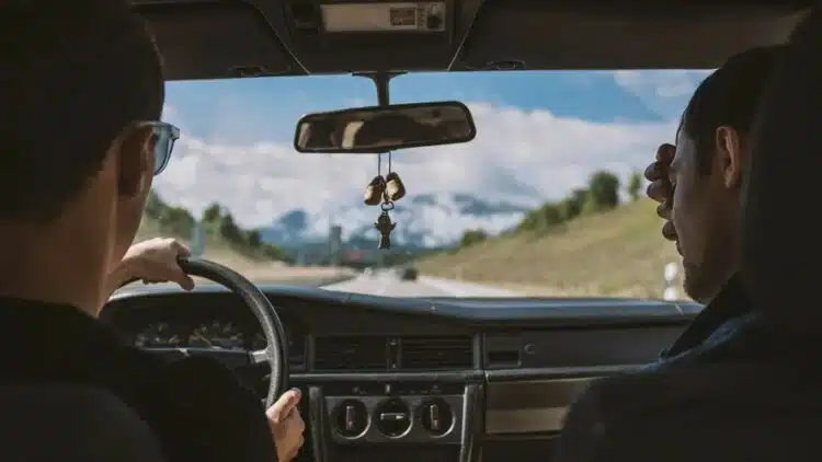 du vyrai vairuotojas ir keleivis vaziuoja automobiliu