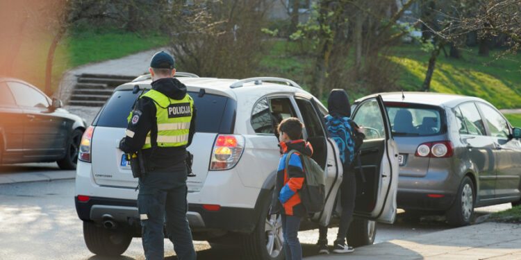 policijos pareigunas stebi vaika automobilis
