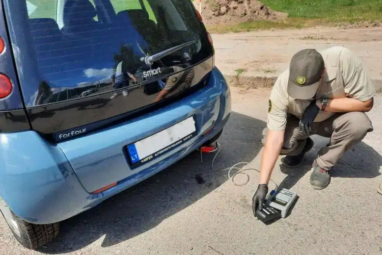 aplinkosaugininkas matuoja automobilio tarsa