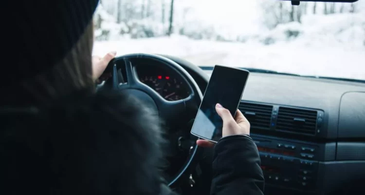 moteris naudojasi telefonu vairuodama bauda baudos