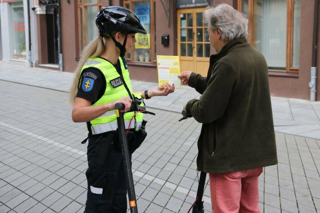 policijos pareigune vyras elektriniai paspirtukai