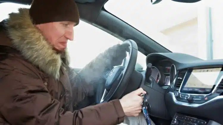 vyras uzveda automobili saltuoju ziemos laiku