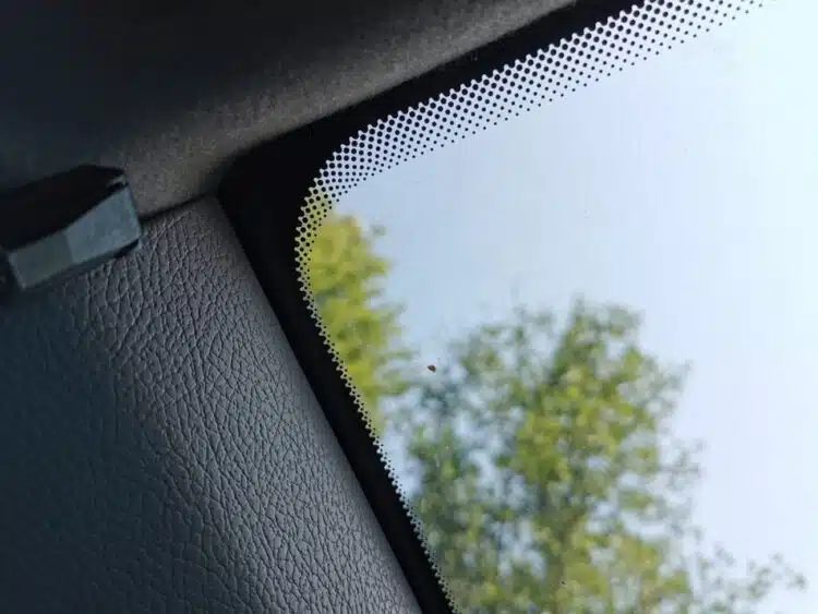 juodi taskai ant priekinio automobilio stiklo