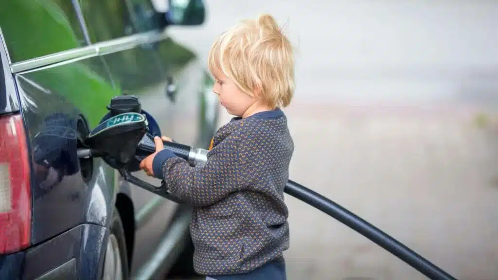 vaikas pila degalus i automobilio baka