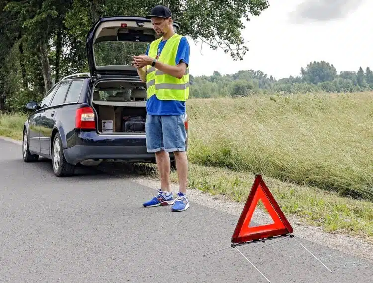 automobilis-stovi-salikeleje-vyras-su-sviesa-atspindincia-liemene-avarinis-trikampis