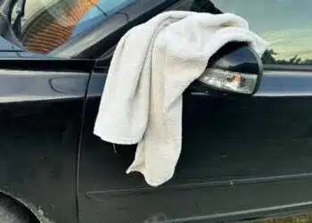 baltas ranksluostis ant automobilio veidrodelio
