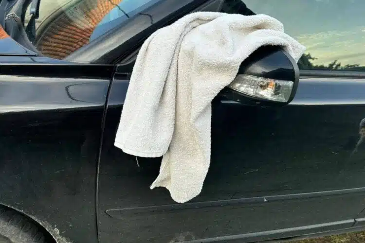 baltas ranksluostis ant automobilio veidrodelio