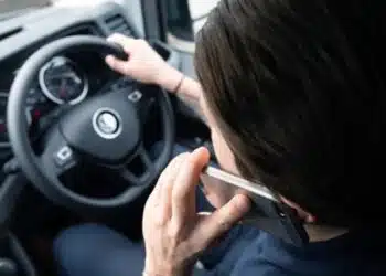 moteris uz automobilio vairo naudojasi telefonu vairuotoja naudojasi telefonu