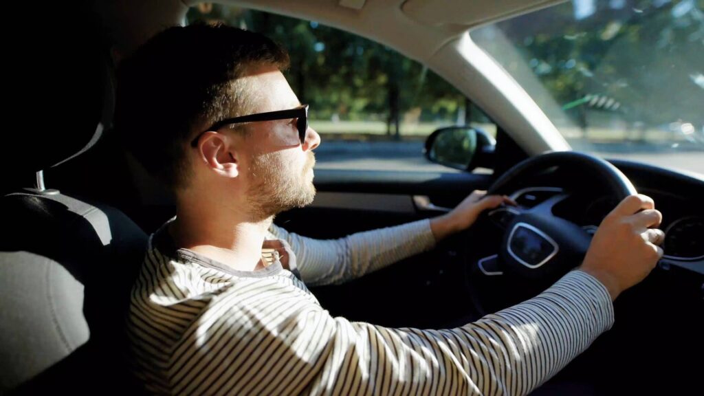 vyras vairuoja automobili su akiniais nuo saules vairuotojas