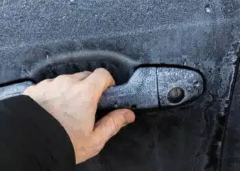 automobilis vyro ranka vyras bando atidaryti automobilio duris ziema uzsalusi spyna