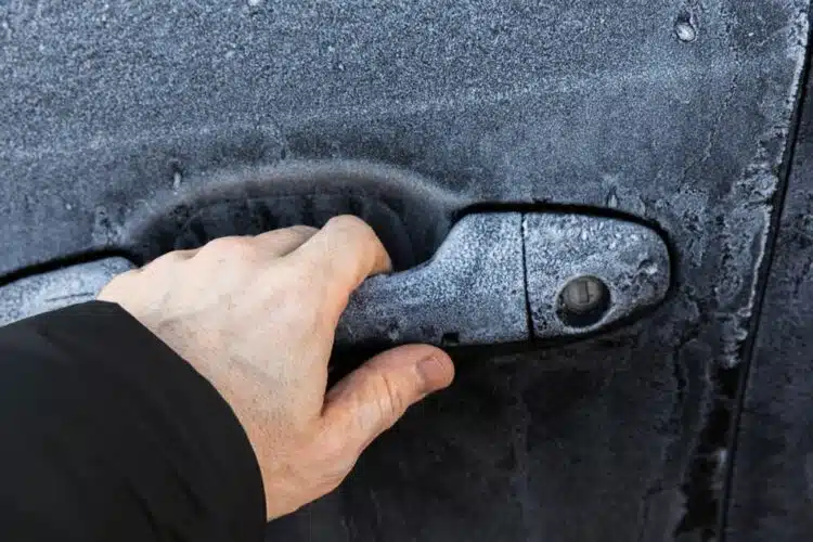 automobilis vyro ranka vyras bando atidaryti automobilio duris ziema uzsalusi spyna