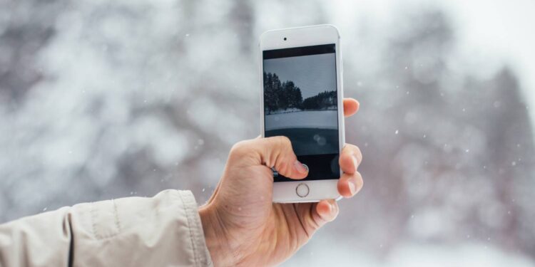 Vyras išmaniuoju telefonu nufotografavo snieguotą žiemą ismanusis telefonas