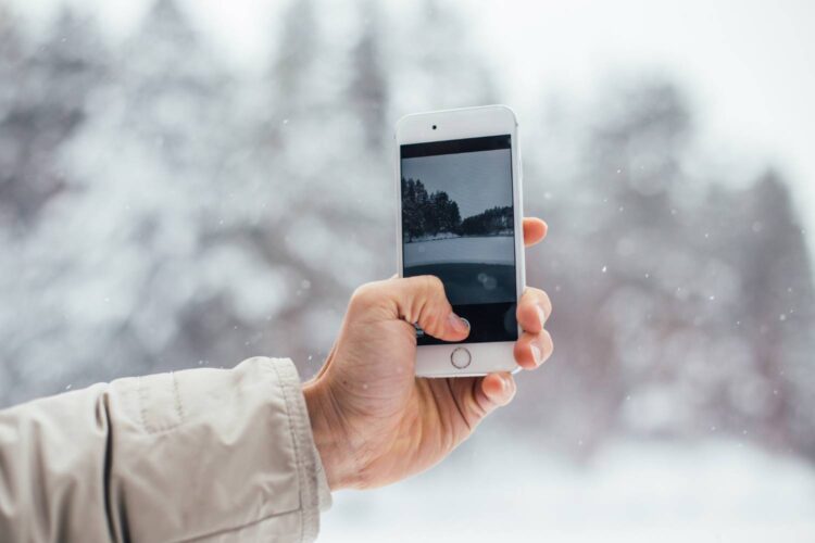 Vyras išmaniuoju telefonu nufotografavo snieguotą žiemą ismanusis telefonas