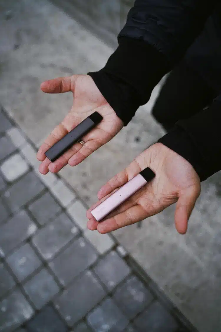 vyras laiko rankose elektronines cigaretes