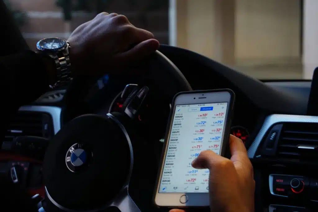 vyras uz bmw automobilio vairo laiko mobiluji telefona rankoje