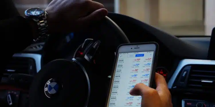 vyras uz bmw automobilio vairo laiko mobiluji telefona rankoje