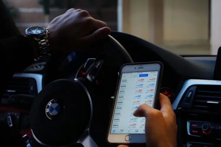 vyras uz bmw automobilio vairo laiko mobiluji telefona rankoje