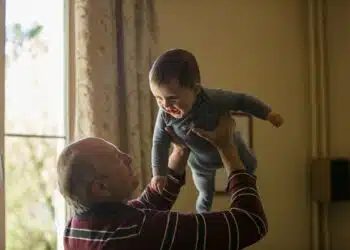 vyresnio amziaus vyras laiko ant ranku kudiki vaika biologinis amzius