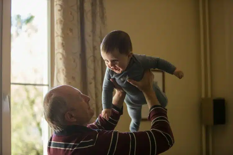 vyresnio amziaus vyras laiko ant ranku kudiki vaika biologinis amzius