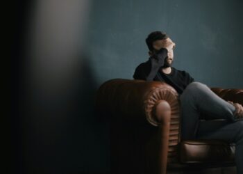 epilepsija galvos skausmas vyras sedi ant sofos susiemes uz galvos