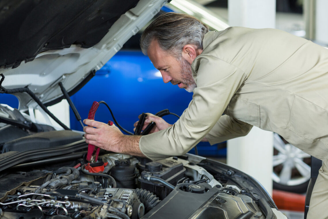 mechanikas tvirtinas automobilio akumuliatoriaus laidus