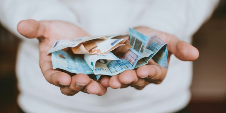 vyras rankose laiko popierines pinigu kupiuras pinigai eurai euru banknotai