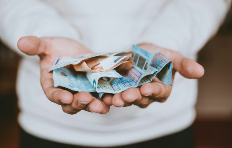 vyras rankose laiko popierines pinigu kupiuras pinigai eurai euru banknotai