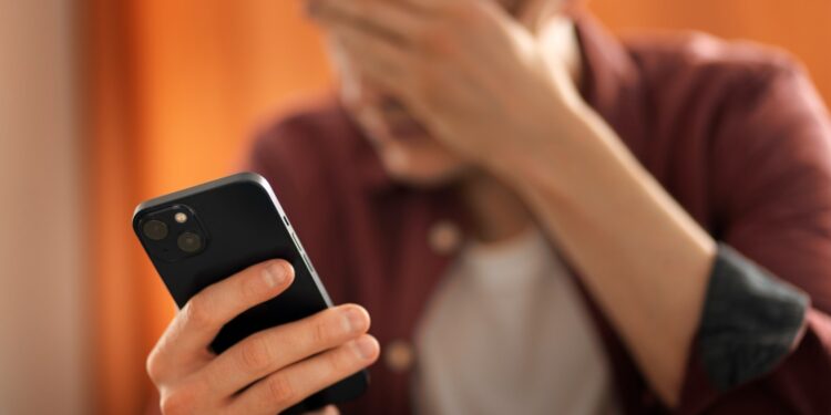 vyras su telefonu rankoje susiemes uz galvos telefoniniai sukciai