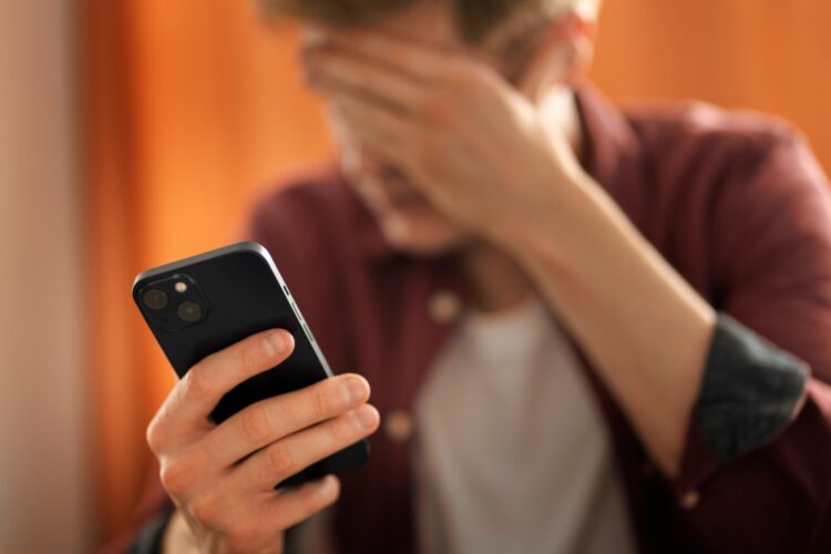 vyras su telefonu rankoje susiemes uz galvos telefoniniai sukciai