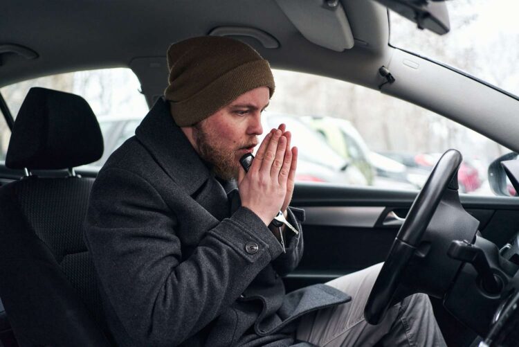 vyras sildosi automobilyje automobilio sildymas ziema