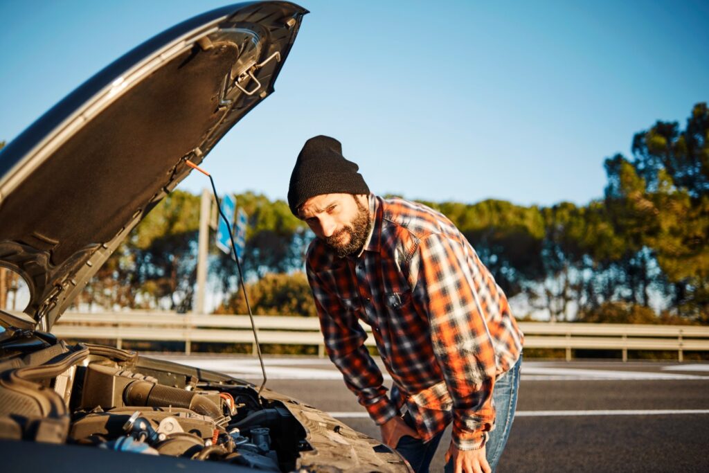 vyras stovi prie atidaryto automobilio variklio dangcio sugedes automobilis sugedo
