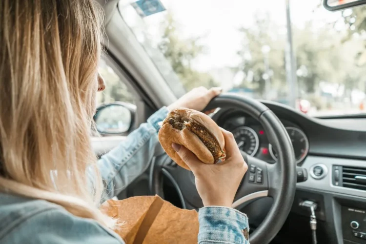 moteris valgo mesaini vairuodama automobili valgymas vairuojant bauda