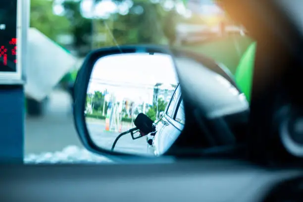 soniniame automobilio veidrodelyje matomas degalu pistoletas