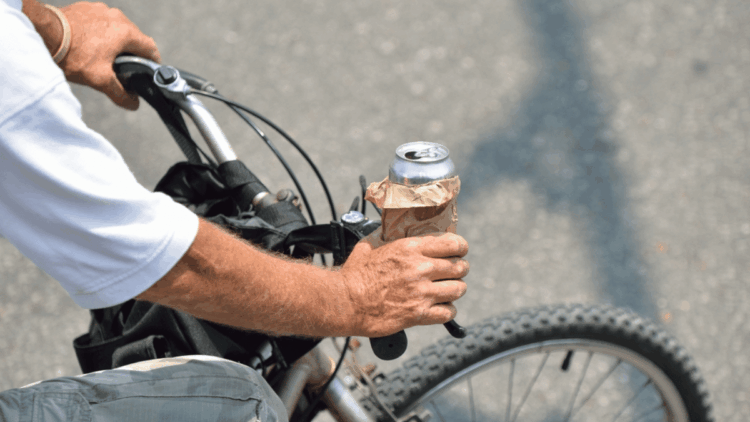 vyras vaziuoja dviraciu ir geria alu alkoholi dviratininkas