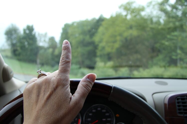 moteris vairuoja automobili vairas ranka