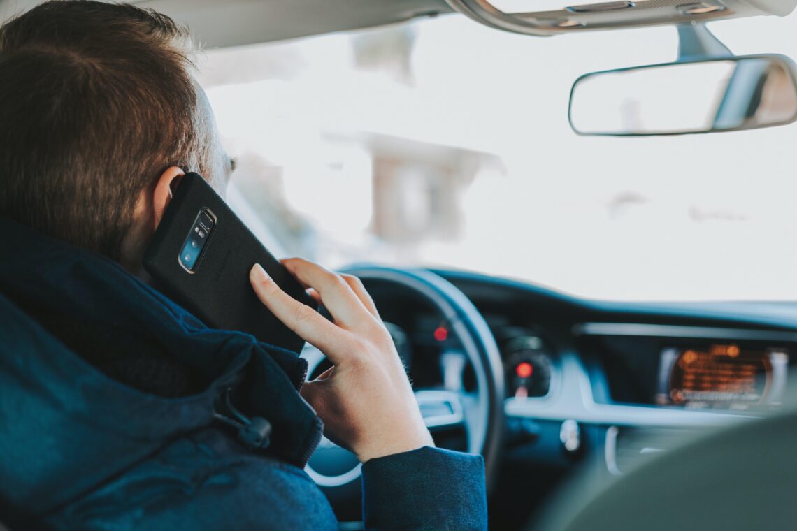 vairuotojas naudojasi mobiliuoju telefonu spustyje kamstyje baudos