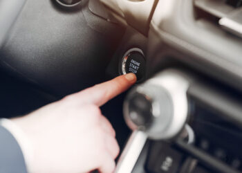Gražus ir elegantiškas vyras automobilių salone automobilio paleidimas variklio uzvedimas