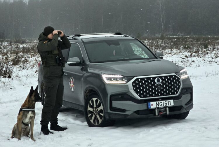 Kontrabandos cunamis Lietuvoje: VSAT smūgis atskleidė šokiruojančius mastus 1 valstybes sienos apsaugos tarnybos pareigunas su tarnybinu sunimi stebi pasieni per ziuronus