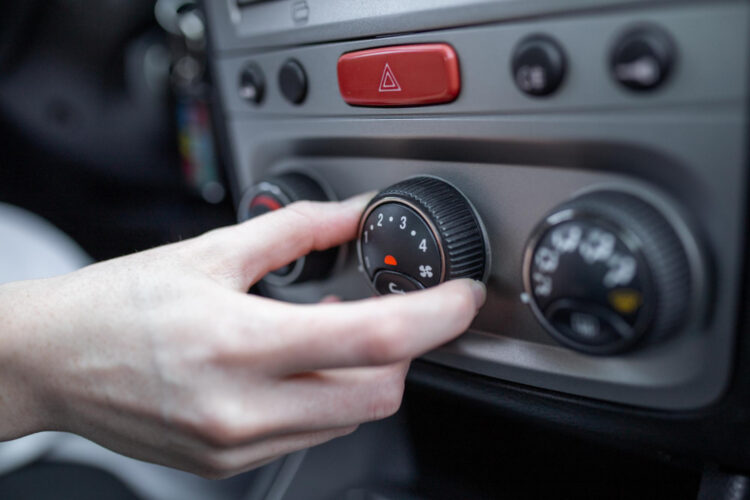 Moteris ranka įjungia automobilio oro kondicionavimo sistemą automobilio oro kondicionieriaus įjungimo ir išjungimo mygtukas vaizdas iš arti oro kondicionierius
