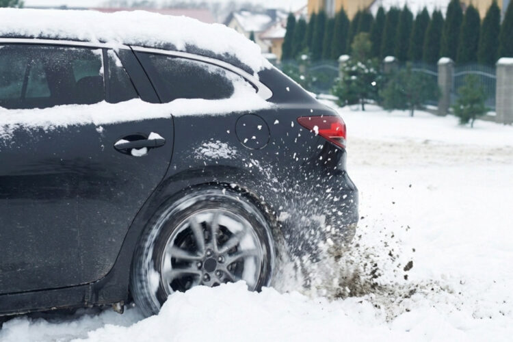 sniege uzklimpes automobilis buksuoja spausdamas gaza