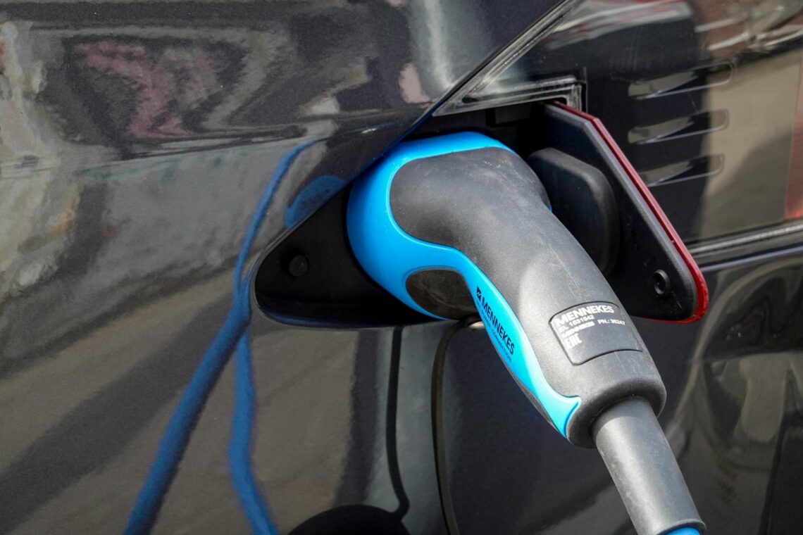Mėlynos ir juodos spalvos ikroviklio antgalis elektromobilyje elektromobilio ikrovimas